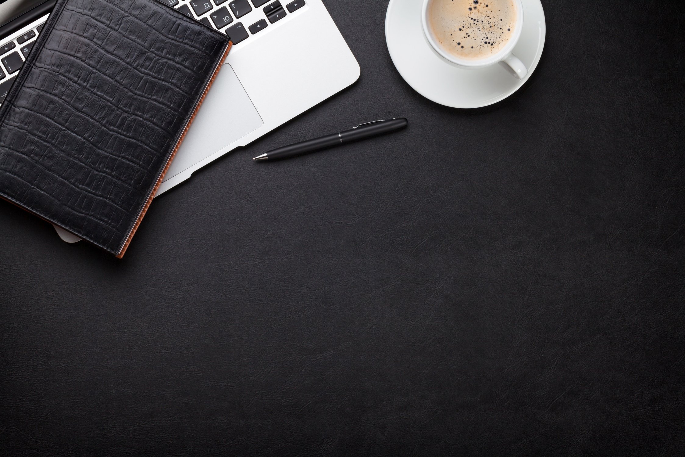 Office desk with laptop, coffee, notepad